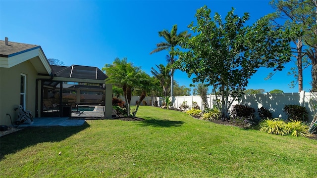 view of yard with glass enclosure and a fenced backyard