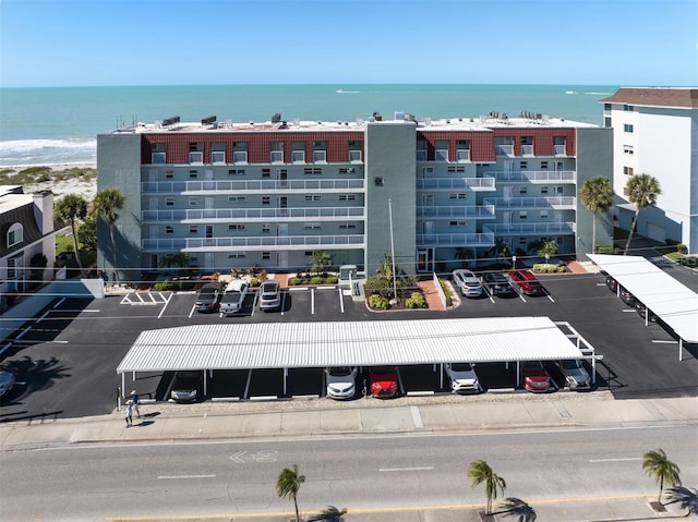 view of building exterior with uncovered parking and a water view