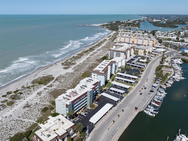 birds eye view of property with a water view and a beach view