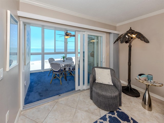 sitting room with light tile patterned floors, baseboards, crown molding, and a ceiling fan