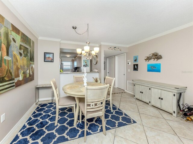 dining room with baseboards, light tile patterned flooring, ornamental molding, a textured ceiling, and a chandelier