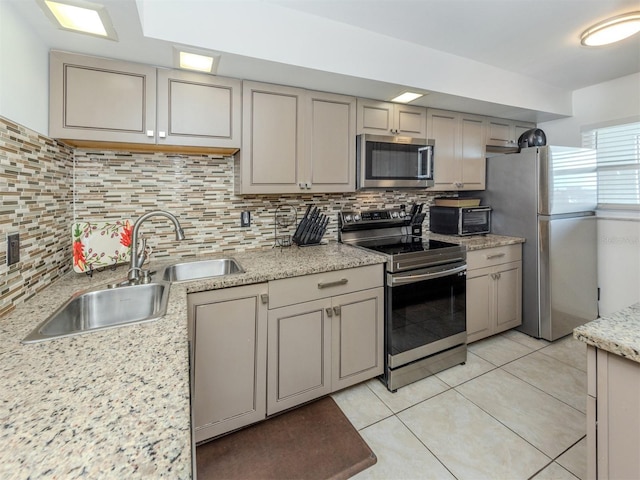 kitchen with light tile patterned floors, tasteful backsplash, appliances with stainless steel finishes, and a sink