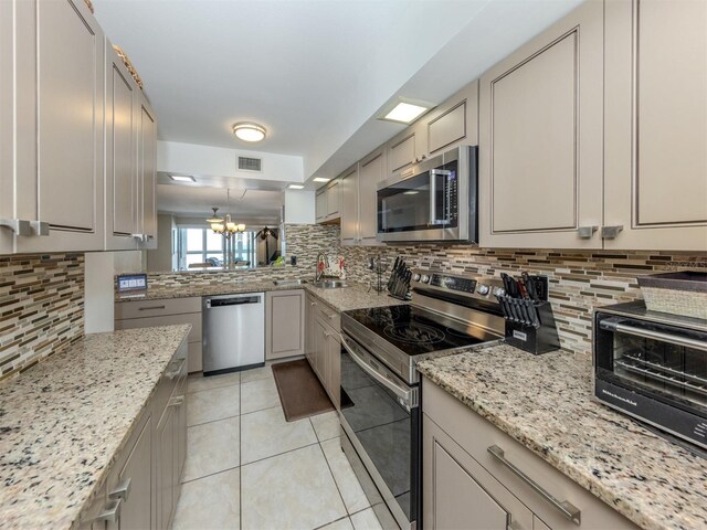 kitchen with visible vents, a chandelier, decorative backsplash, light tile patterned flooring, and stainless steel appliances
