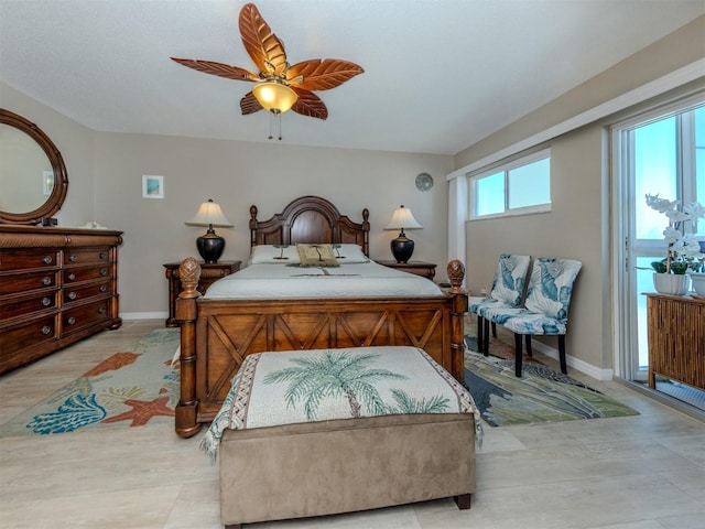 bedroom featuring light wood-type flooring, baseboards, and a ceiling fan