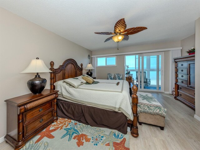 bedroom with baseboards, a textured ceiling, wood finished floors, and a ceiling fan