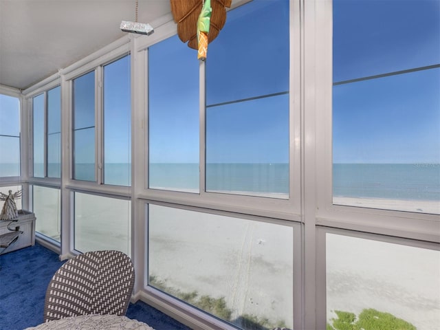 unfurnished sunroom with ceiling fan and a water view