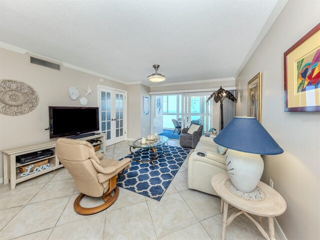 tiled living room featuring french doors, a textured ceiling, visible vents, and crown molding