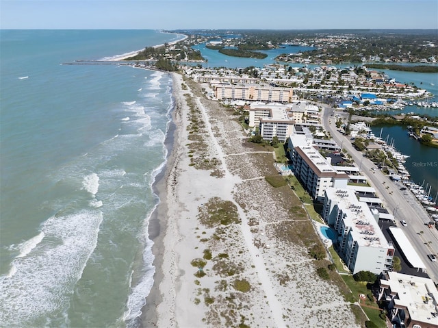 drone / aerial view featuring a water view, a city view, and a beach view