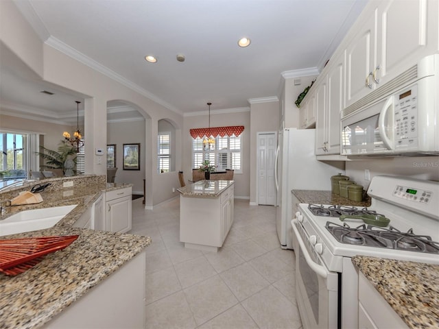 kitchen with ornamental molding, a sink, a center island, white appliances, and white cabinets