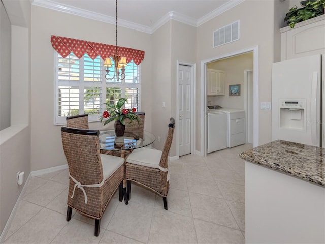 dining room featuring visible vents, a chandelier, ornamental molding, light tile patterned floors, and separate washer and dryer