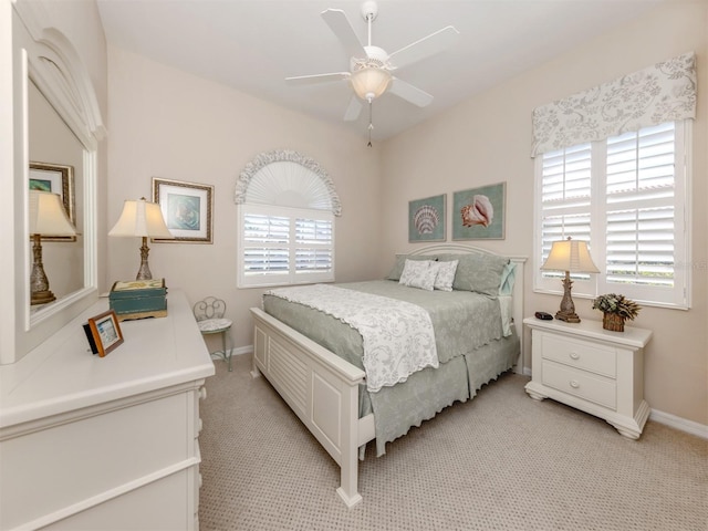 bedroom with light carpet, multiple windows, and baseboards