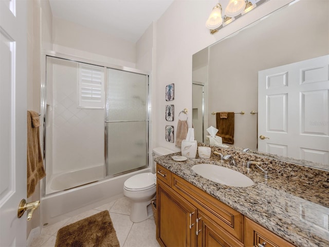 bathroom with tile patterned flooring, combined bath / shower with glass door, toilet, and vanity