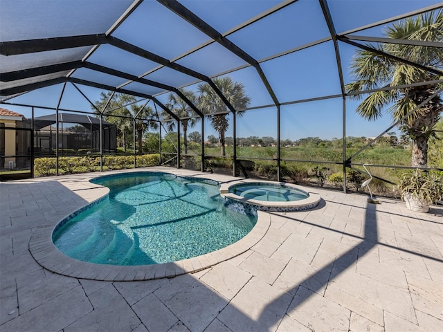 view of pool featuring a pool with connected hot tub, a lanai, and a patio area