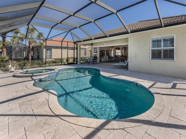 view of pool featuring a patio, a ceiling fan, a pool with connected hot tub, and a lanai