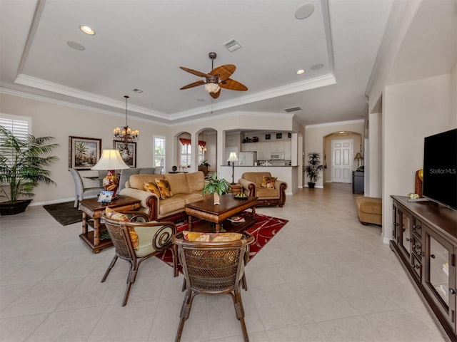 living area with arched walkways, a raised ceiling, and crown molding