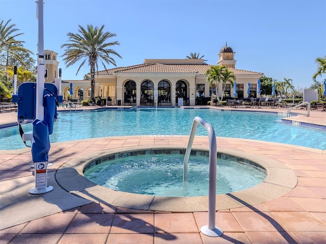 community pool with a hot tub and a patio area