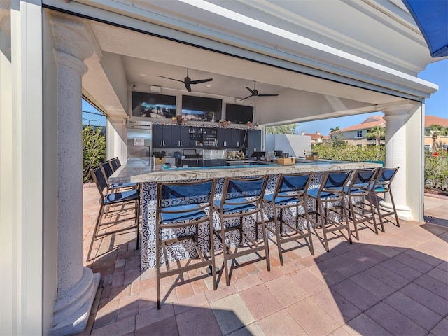 view of patio / terrace featuring outdoor dry bar and a ceiling fan