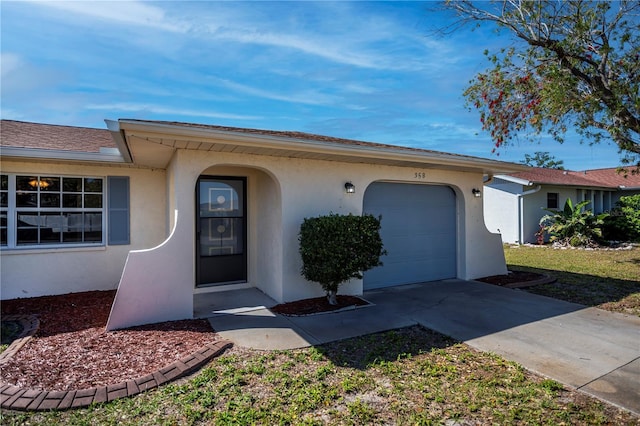 view of front of property featuring stucco siding, an attached garage, and concrete driveway