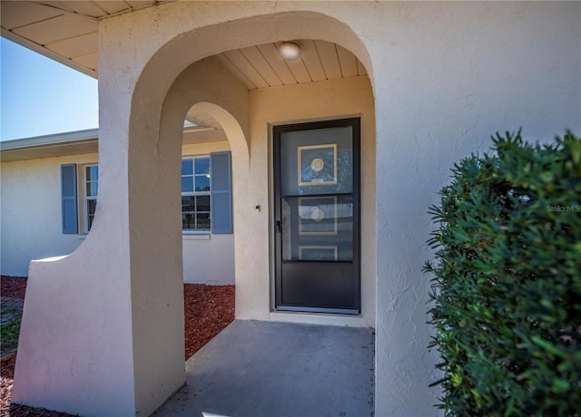 entrance to property featuring stucco siding