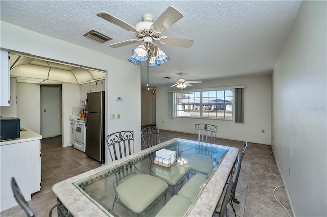 358 Pineview Dr, Venice, FL 34293 - tiled dining space featuring visible vents, a textured ceiling, and a ceiling fan