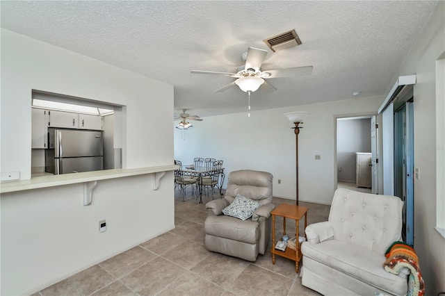358 Pineview Dr, Venice, FL 34293 - living area featuring visible vents, a textured ceiling, light tile patterned flooring, and a ceiling fan