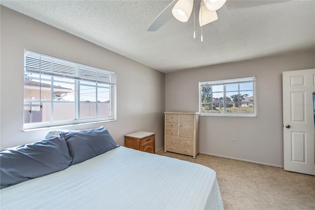 358 Pineview Dr, Venice, FL 34293 - bedroom with baseboards, multiple windows, a textured ceiling, and a ceiling fan