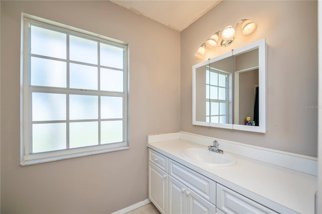 358 Pineview Dr, Venice, FL 34293 - bathroom with plenty of natural light, a textured ceiling, vanity, and baseboards