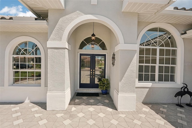 property entrance featuring stucco siding and french doors