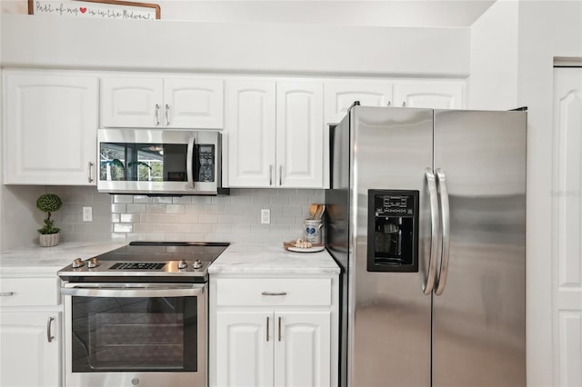 kitchen with light stone counters, tasteful backsplash, appliances with stainless steel finishes, and white cabinetry