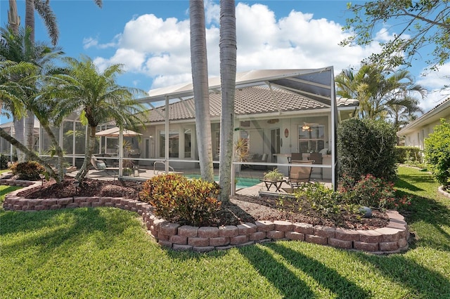 rear view of property with a lanai, a yard, and a patio area