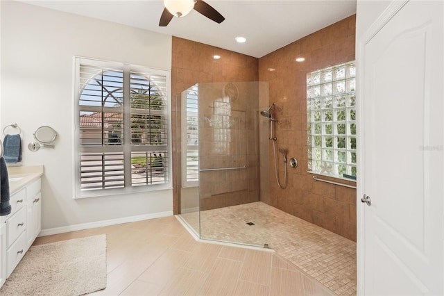 bathroom with vanity, a walk in shower, baseboards, and a ceiling fan