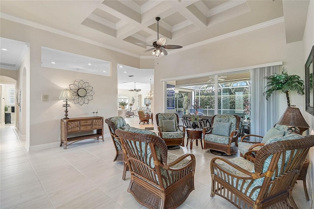 living area featuring arched walkways, plenty of natural light, crown molding, and ceiling fan