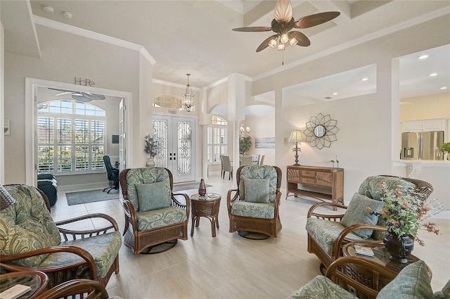 living area with french doors, a ceiling fan, a towering ceiling, and crown molding