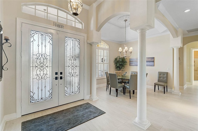 entryway featuring french doors, arched walkways, and ornamental molding