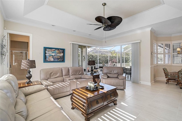 living area with a ceiling fan, light tile patterned flooring, a sunroom, crown molding, and a raised ceiling