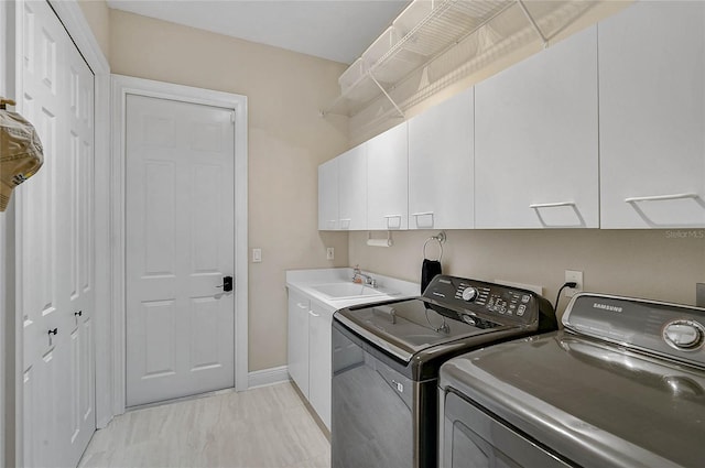 laundry area with washer and dryer, cabinet space, baseboards, and a sink