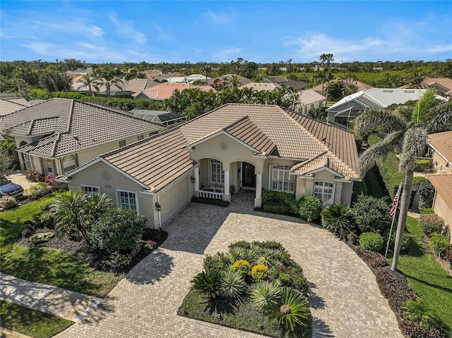 exterior space with driveway, an attached garage, stucco siding, a tile roof, and a residential view