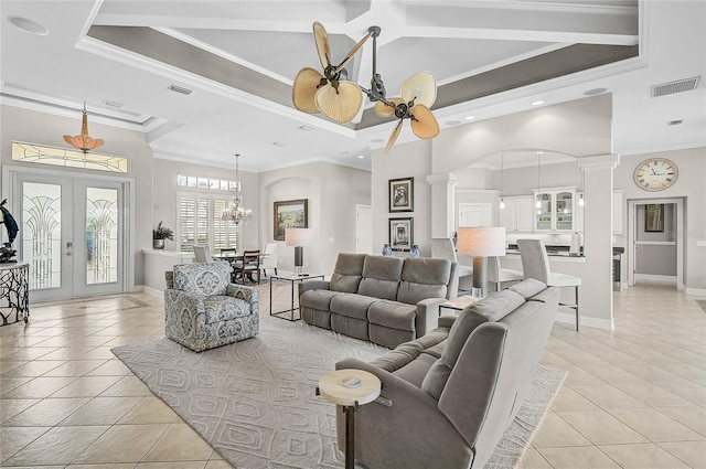 living room with visible vents, ornamental molding, a tray ceiling, light tile patterned flooring, and ornate columns