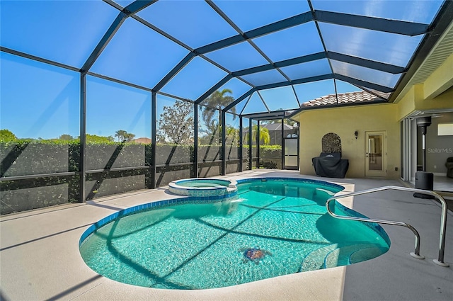 view of pool with glass enclosure, a patio, and a pool with connected hot tub