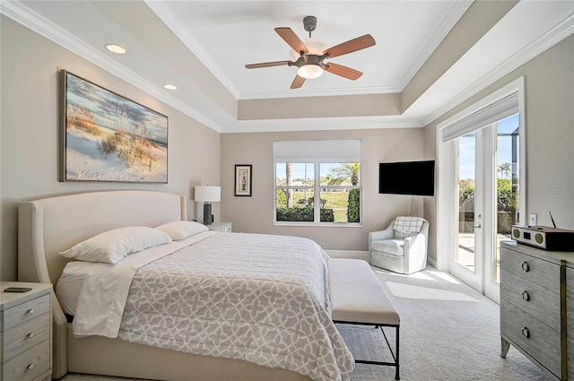 carpeted bedroom with access to exterior, multiple windows, a raised ceiling, and ornamental molding