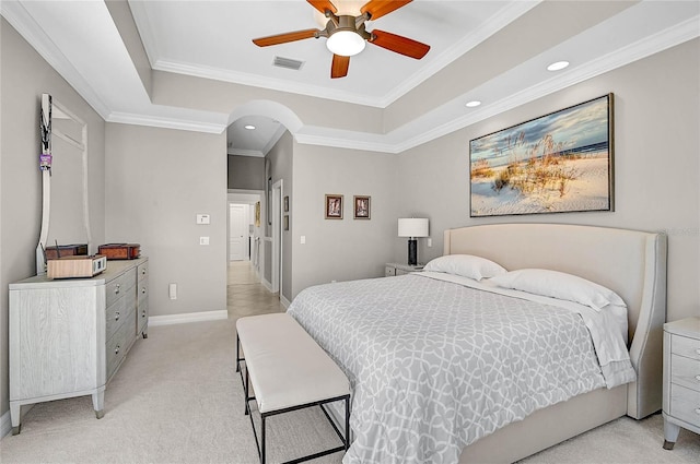 bedroom with visible vents, a raised ceiling, and light colored carpet