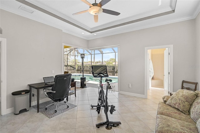 office space with baseboards, light tile patterned floors, a sunroom, a raised ceiling, and a ceiling fan