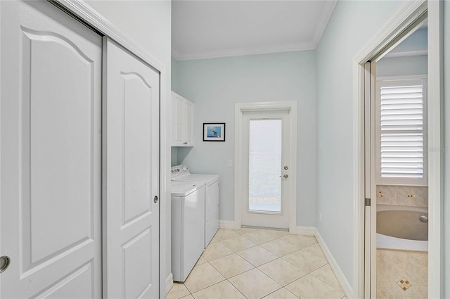 laundry area featuring baseboards, light tile patterned flooring, cabinet space, crown molding, and washer and clothes dryer