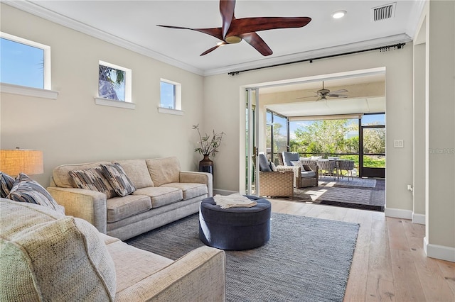 living area with light wood-type flooring, baseboards, ceiling fan, and crown molding