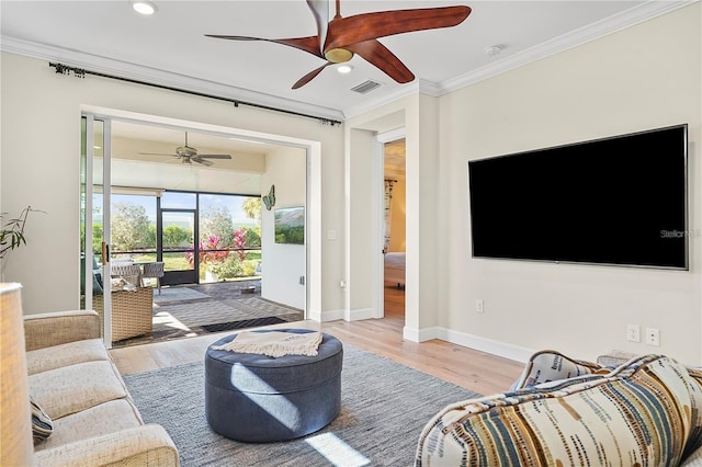 living room featuring wood finished floors, a ceiling fan, visible vents, and ornamental molding