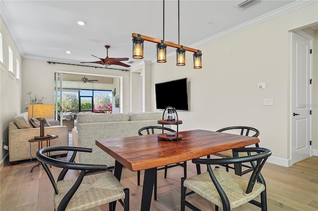dining room featuring crown molding, visible vents, a ceiling fan, and baseboards
