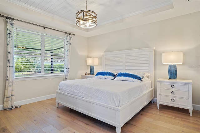 bedroom with baseboards, light wood-style floors, and crown molding