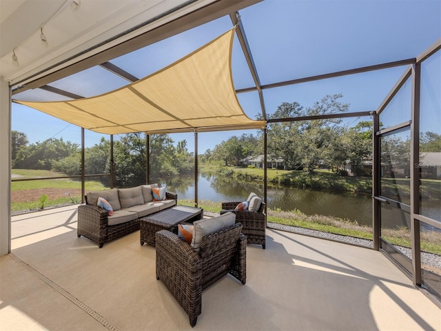 sunroom with rail lighting and a water view