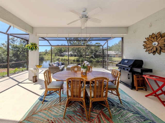 sunroom featuring a ceiling fan and a water view