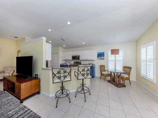 kitchen featuring stainless steel appliances, baseboards, light tile patterned flooring, and white cabinets